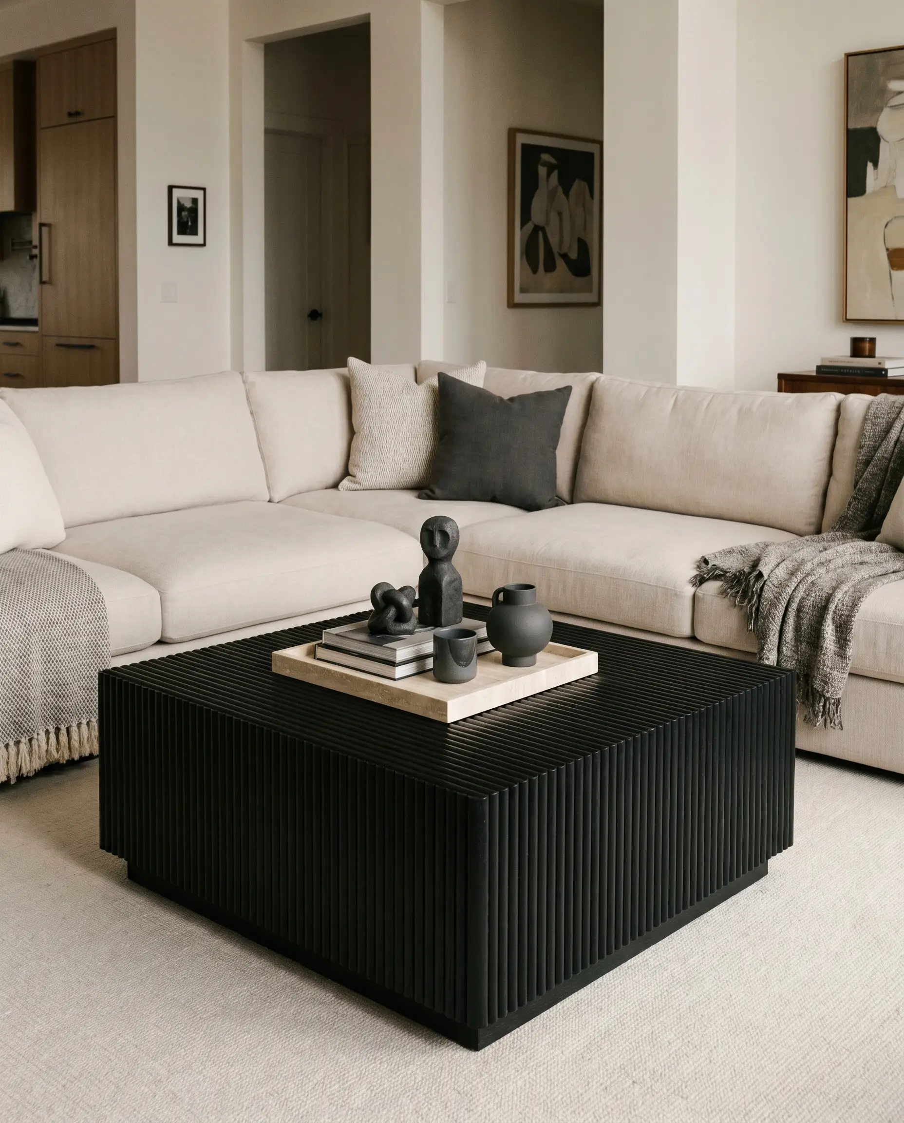 A matte black stained fluted oak coffee table featuring rigid vertical detailing contrasts a pale sofa and Benjamin Moore Cheating Heart decor.