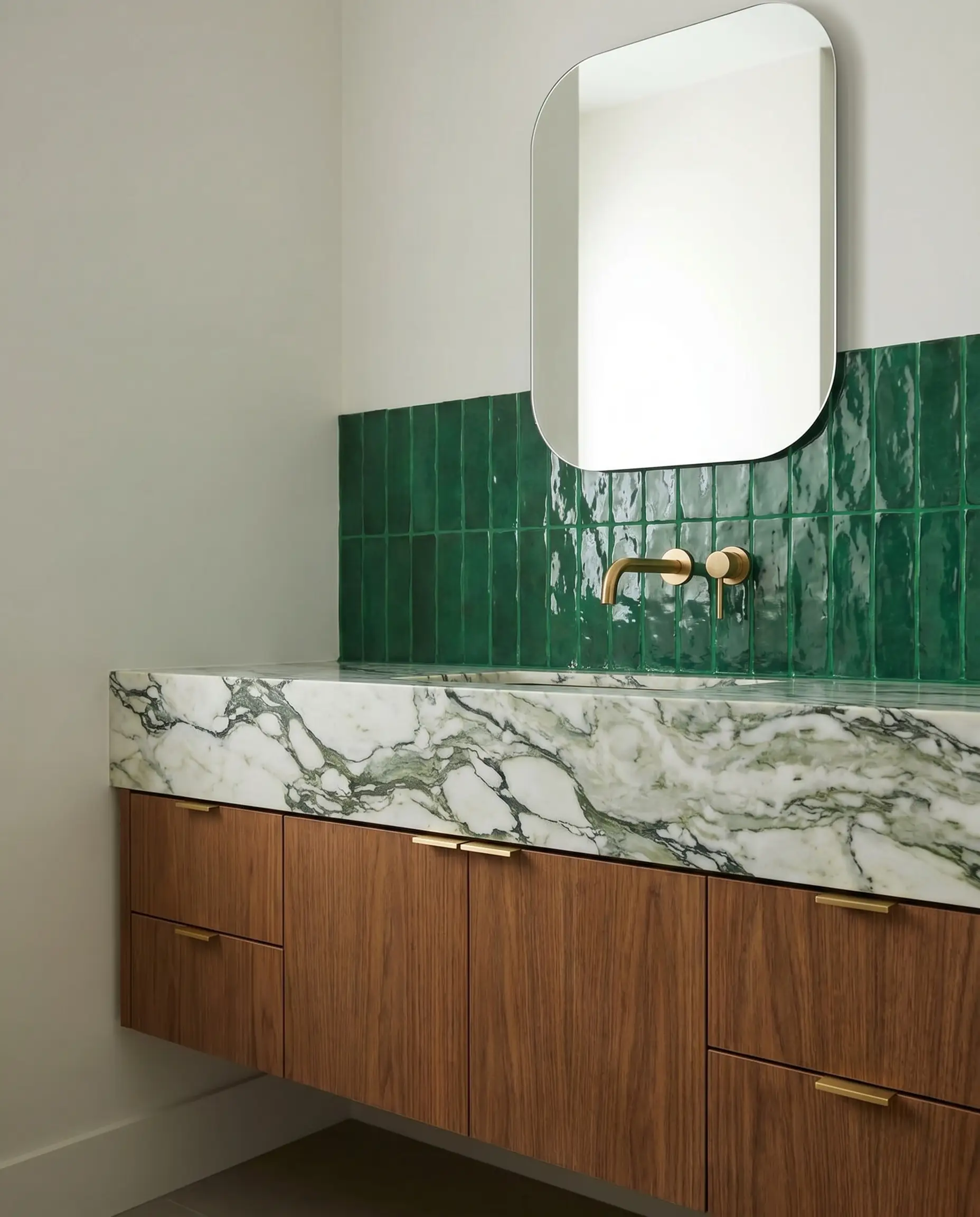 A heavily veined marble countertop meets a highly textural Moroccan clay wall installed with custom-matched green epoxy grout to create a monolithic surface.
