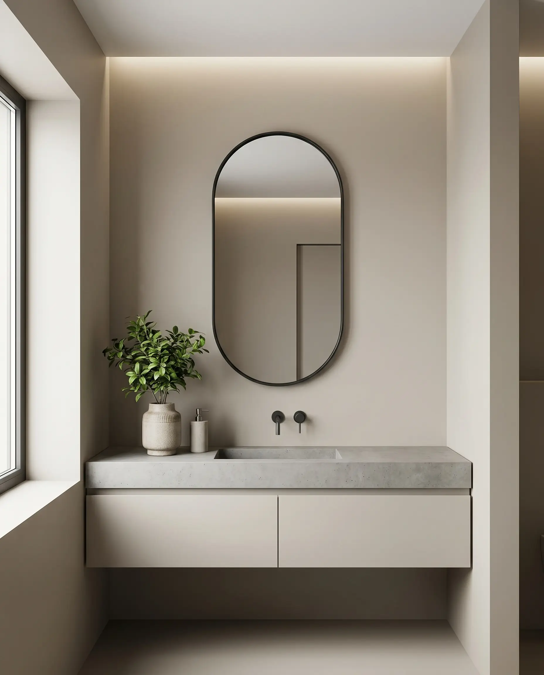 A pill-shaped mirror framed in thin matte black steel hangs above a sleek minimalist vanity adorned with a small potted green plant.