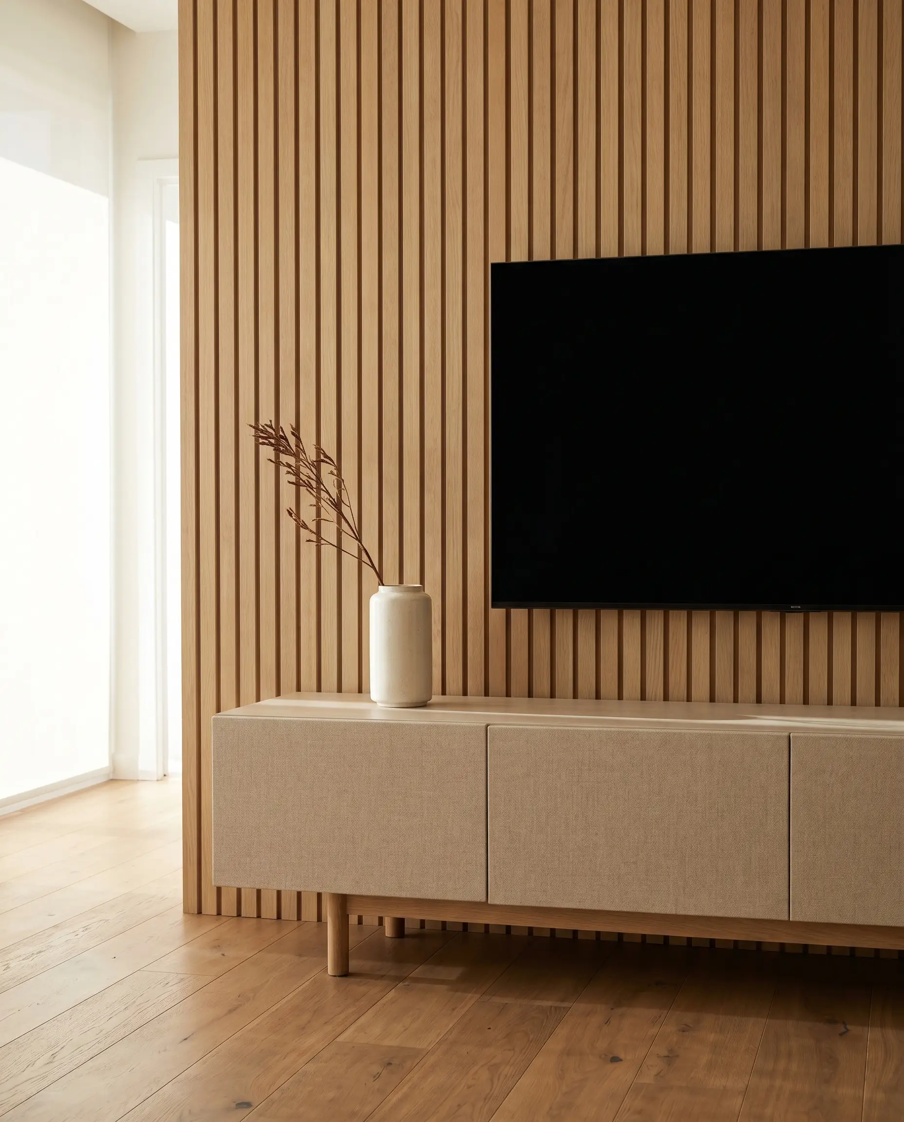 Rift-sawn white oak slats with an MDF core form a structured backdrop in this wood slat tv wall modern living room featuring a neutral fabric console.