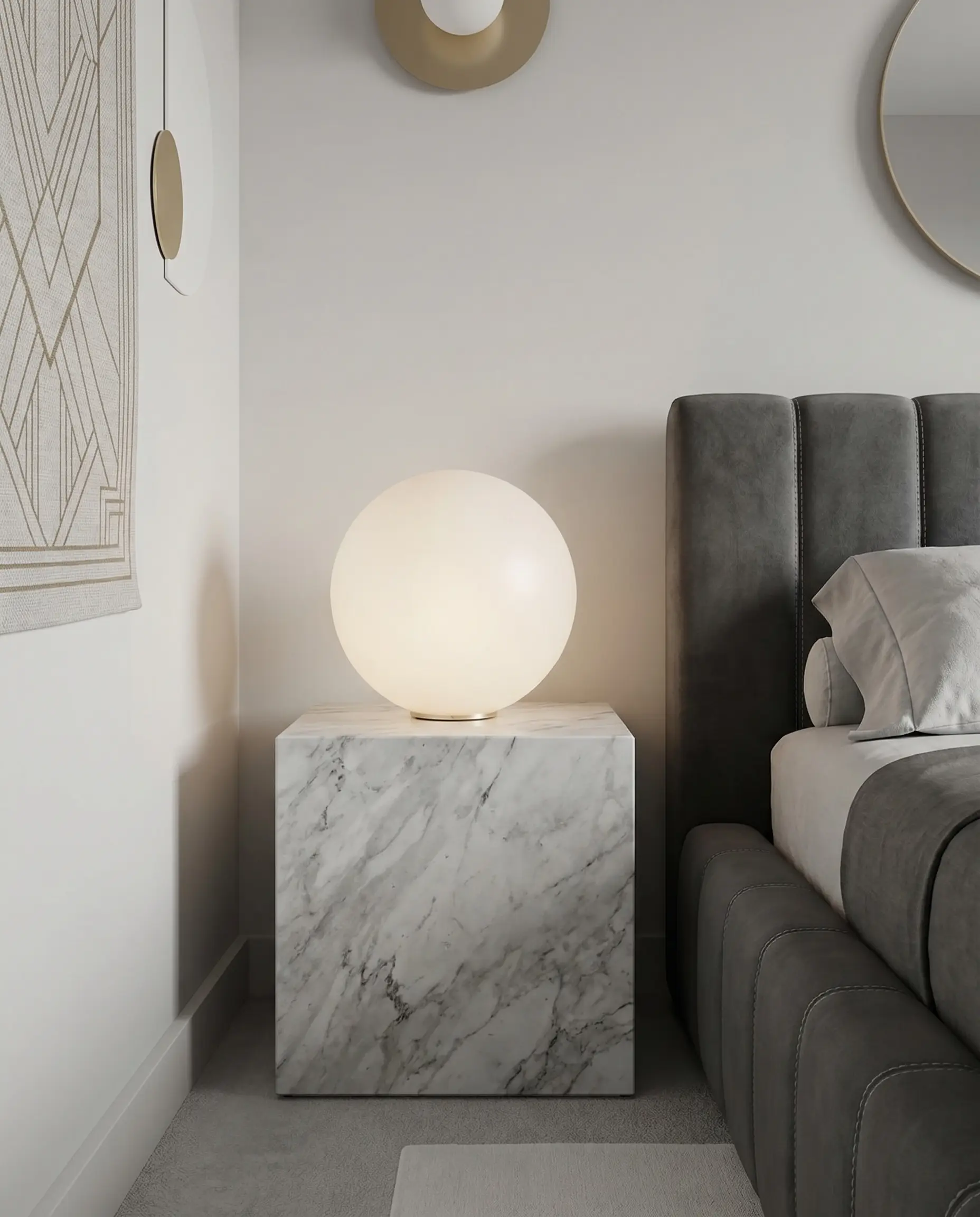 A perfectly spherical frosted glass lamp rests on a rectangular marble block nightstand next to a linear channel-tufted bed frame in a 1920s style bedroom.