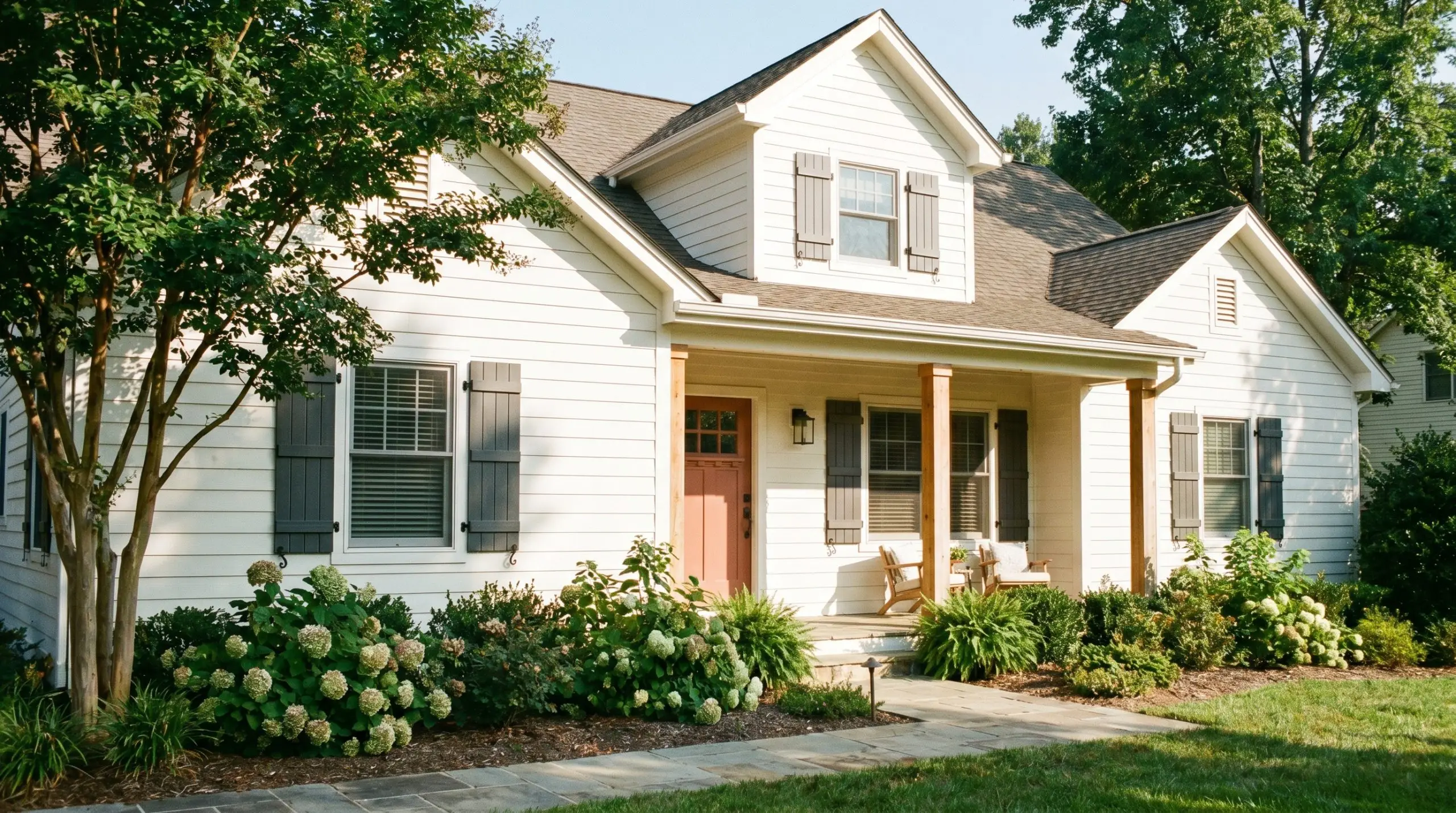Natural cedar architectural columns and a muted terracotta front door frame traditional exterior lap siding painted in Sherwin-Williams Westhighland White (Hex #F3EEE3).