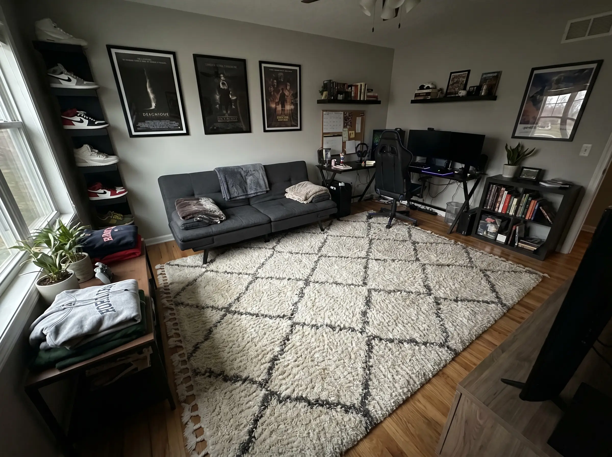 A thick, machine-washable Moroccan shag area rug covers the floor beneath a sleek futon and a modern gaming desk.