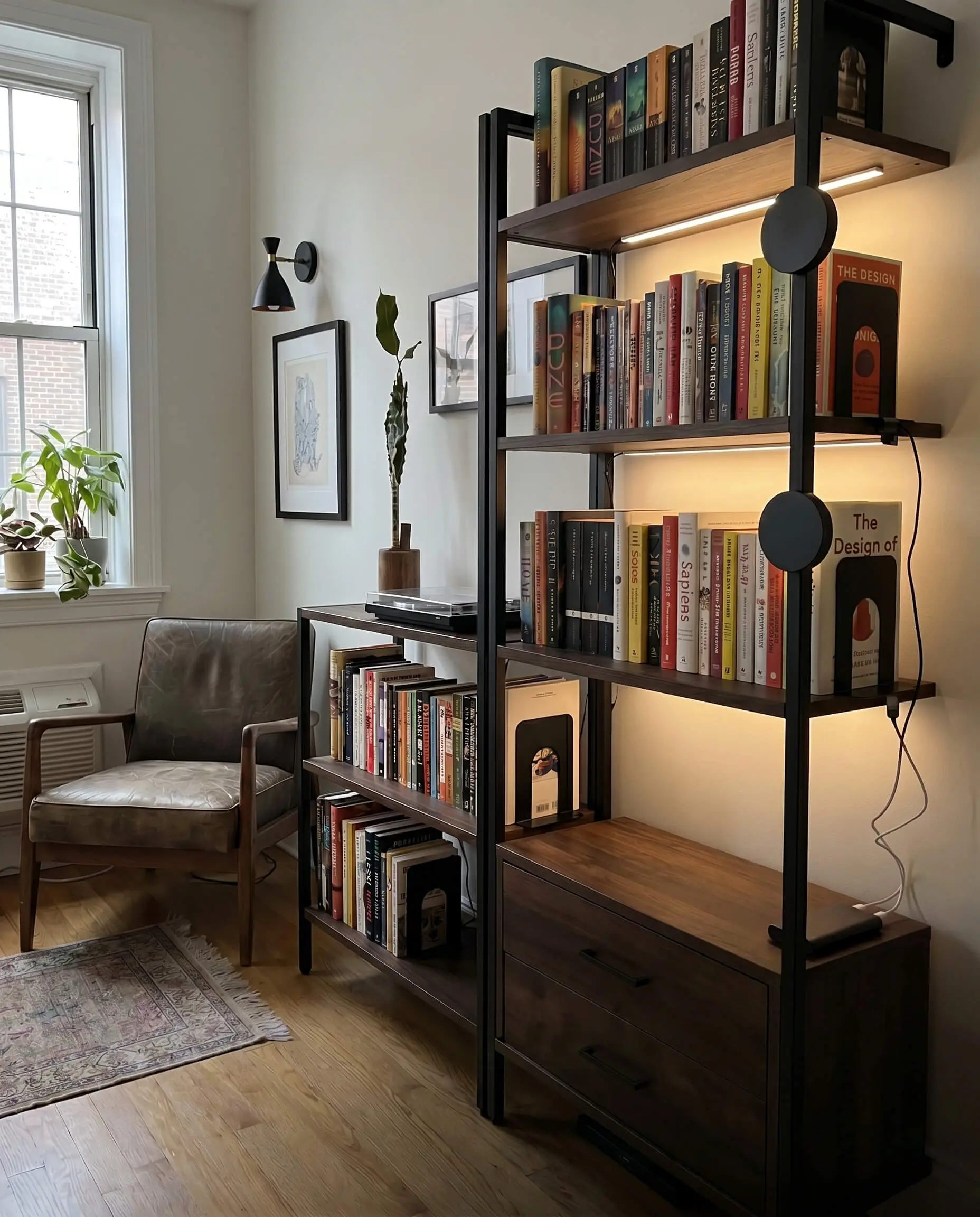 Matte black aluminum magnetic pucks hide behind the front lip of the shelves, providing ambient task lighting for an accessible apartment library.