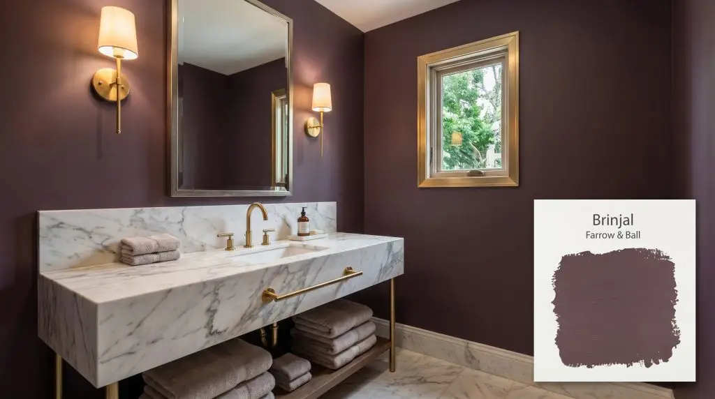 A luxurious powder room featuring a Calacatta marble vanity and brushed gold fixtures set against Farrow & Ball Brinjal (Hex #5e4449) walls.
