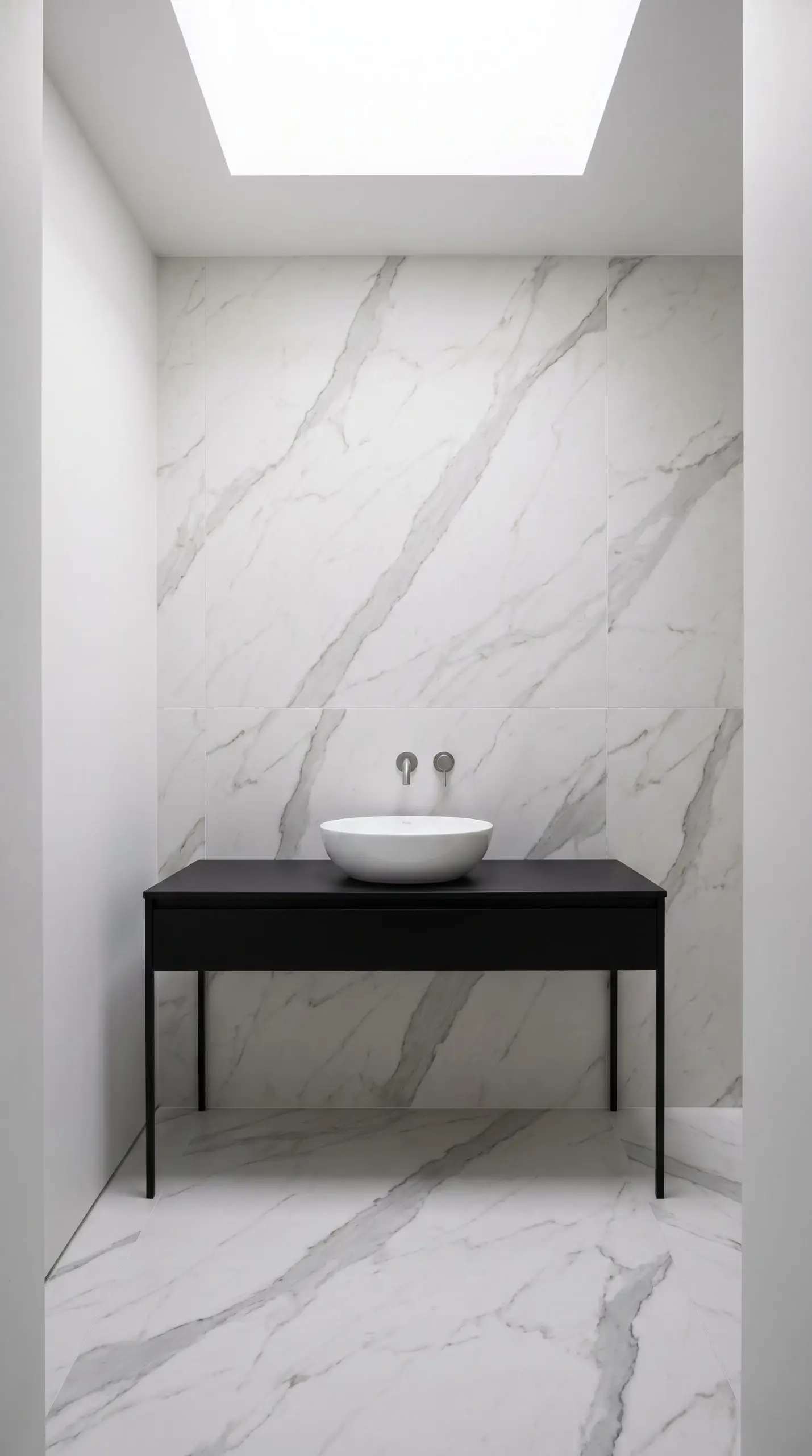 Calacatta marble-look porcelain tiles run continuously from the floor up the wall behind a thin matte black vanity console and white ceramic vessel sink.