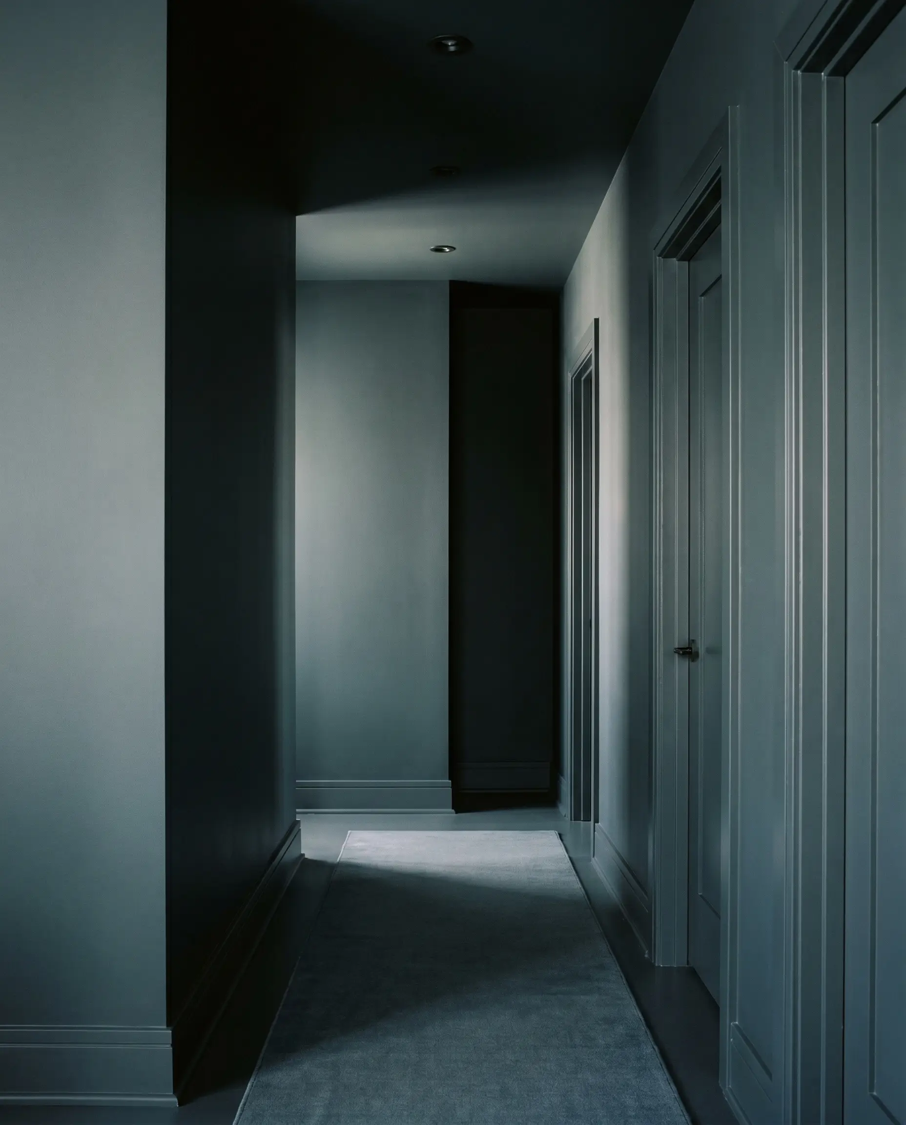 Matte Benjamin Moore Regent Green walls and satin trim create a continuous color-drenched narrow hallway wall decor without any bulky furniture.