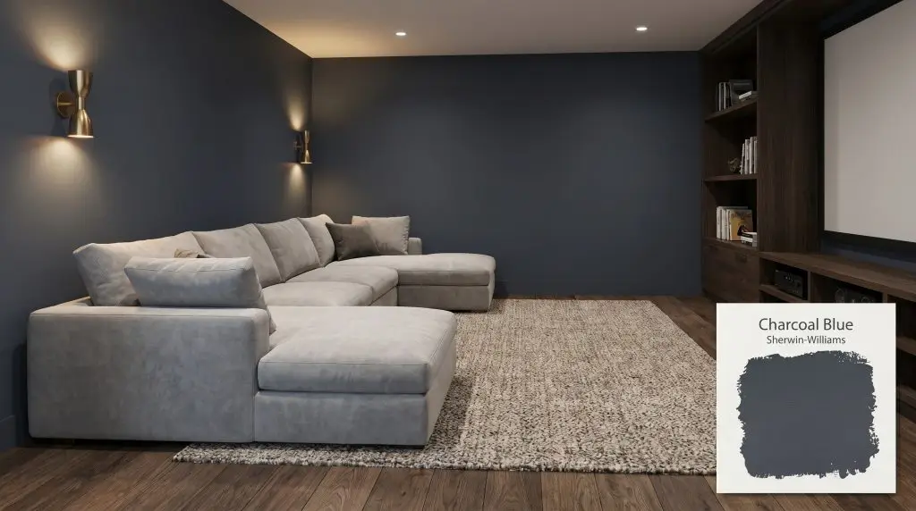 Warm ambient sconce lighting illuminates a plush light gray sectional and dark oak floors against Sherwin-Williams Charcoal Blue (Hex #3D4450) walls.