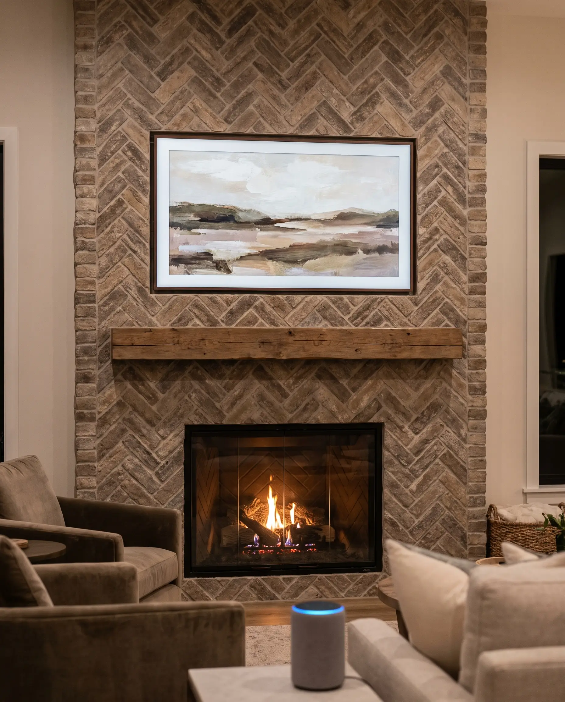 An integrated digital display mounts ultra-flush directly above the exact apex of a highly textured herringbone fireplace surround in a modern living room.