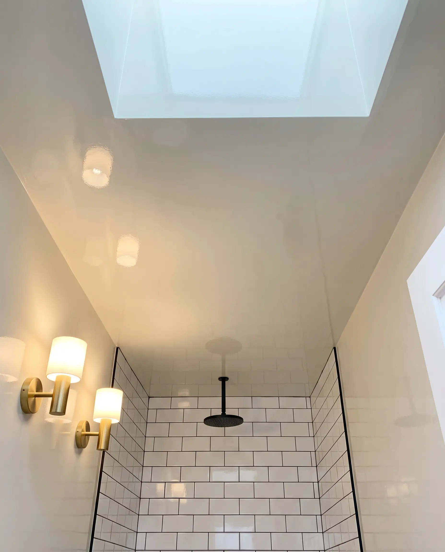 A small bathroom design showcasing a Farrow and Ball All White high-gloss ceiling above a compact shower zone with crisp white subway tiles.