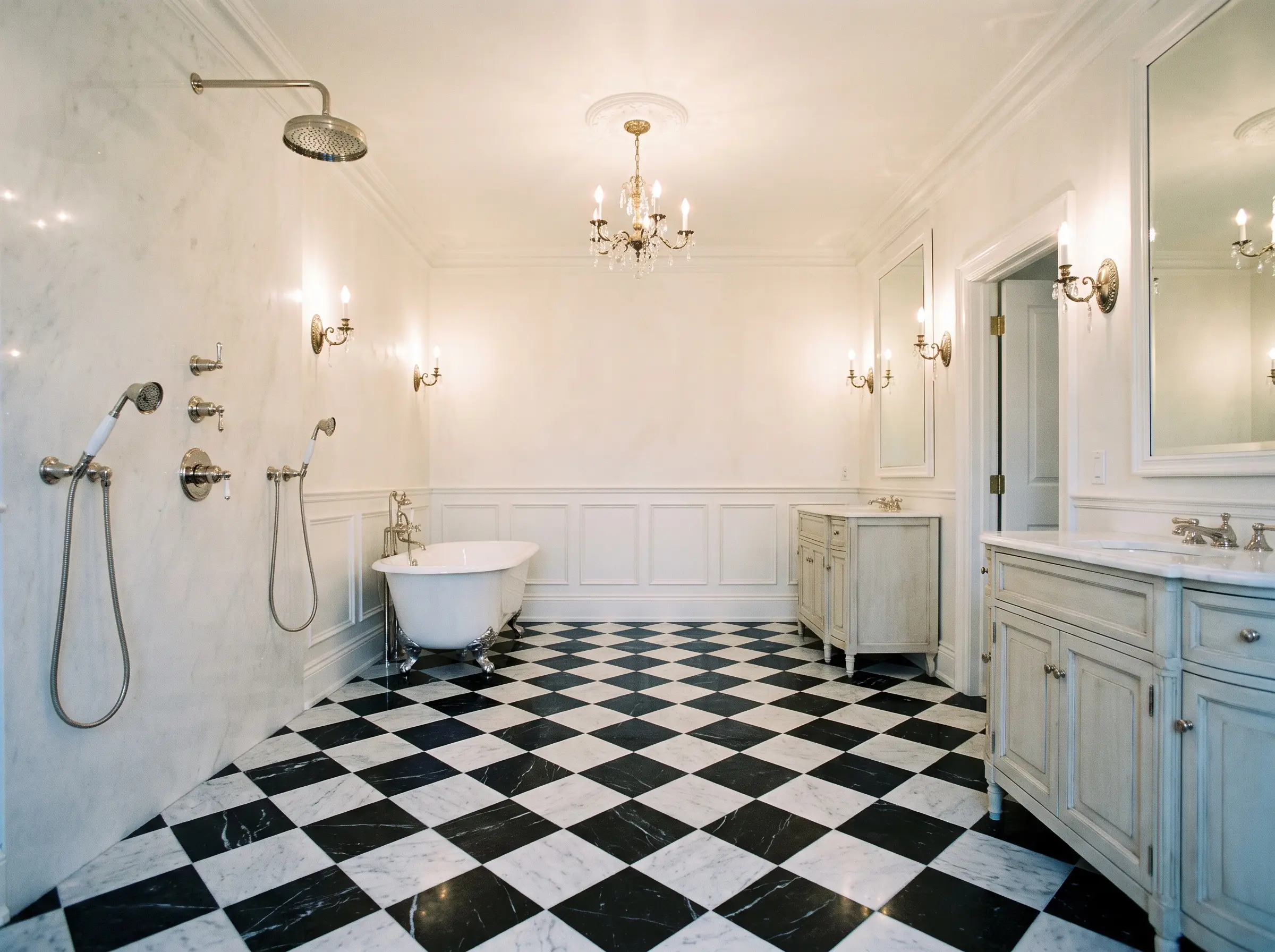 A honed marble checkerboard floor of Matte Carrara and Nero Marquina tiles extends seamlessly toward a freestanding clawfoot tub and crisp white wainscoting.
