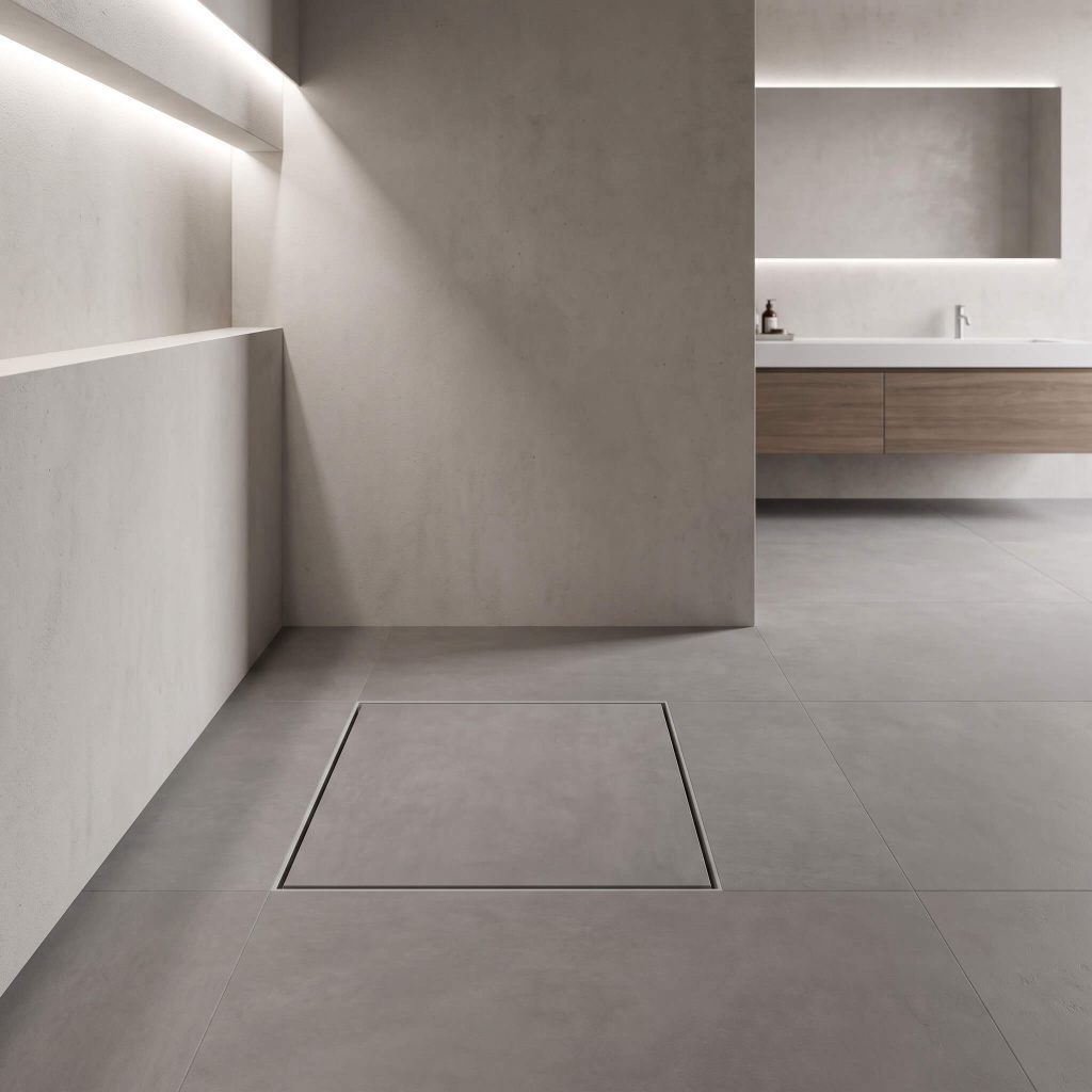 A perfectly cut square of matte gray porcelain floor tile sits directly over a grate to camouflage an invisible tile-insert center drain near a sleek freestanding vanity.