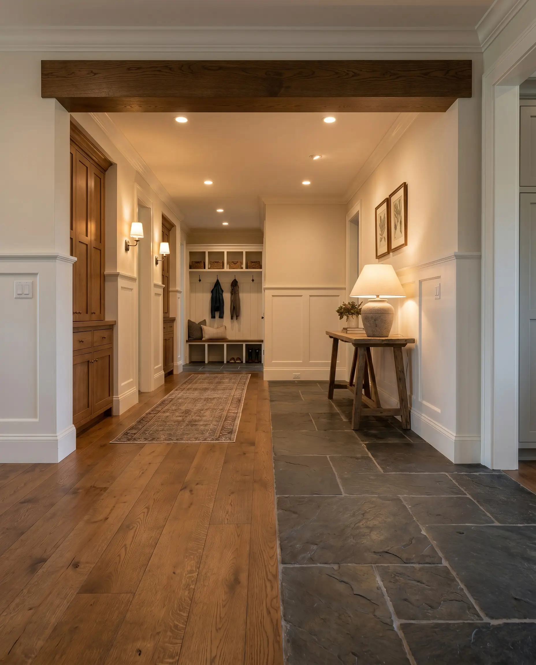 A perpendicular header board of solid 3/4-inch rift-sawn oak creates a picture frame threshold capping field flooring against natural slate floor tiles.