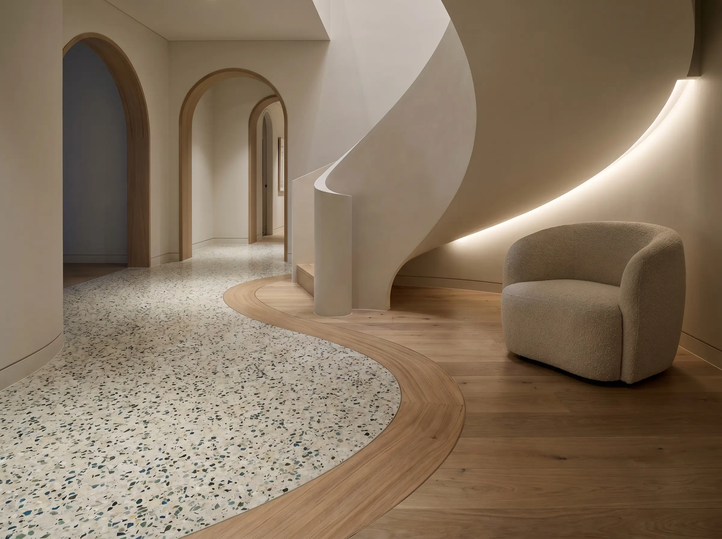 A sweeping arc of poured terrazzo floor meets a flexible curved wood-bending ply border and hardwood flooring around a spiral staircase base.