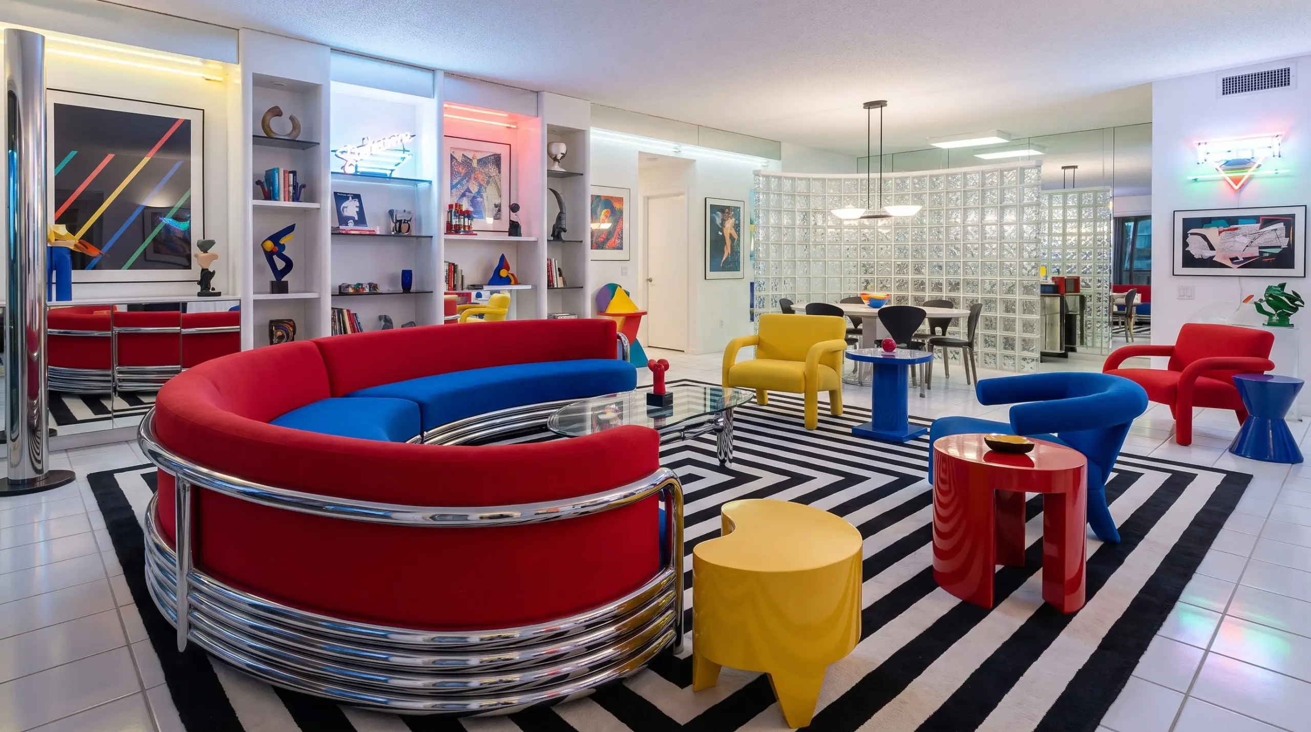 A curved sofa silhouette supported by a chunky polished tubular chrome frame stands out brilliantly against a stark geometric black-and-white striped rug.