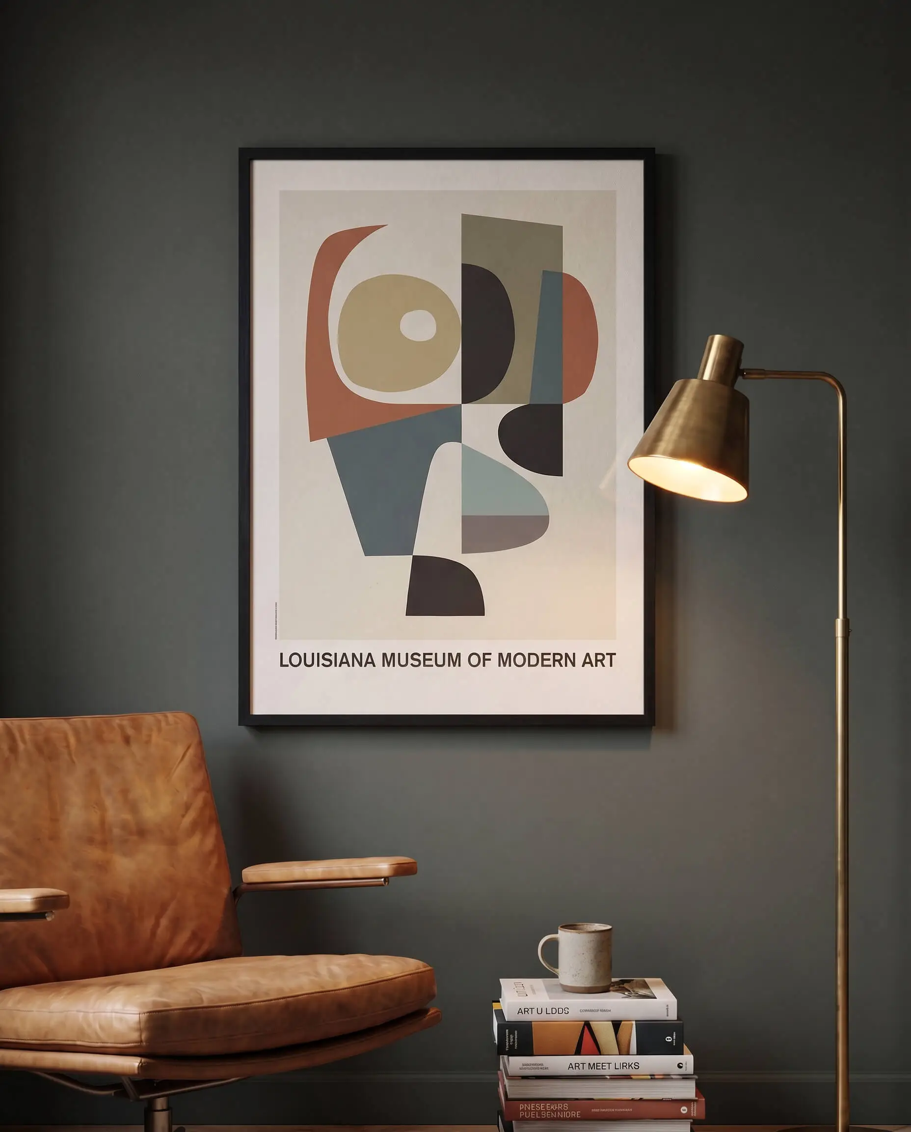A black framed Louisiana Museum of Modern Art print hangs on a Studio Green wall showcasing interior decorating using posters near a tan leather chair.