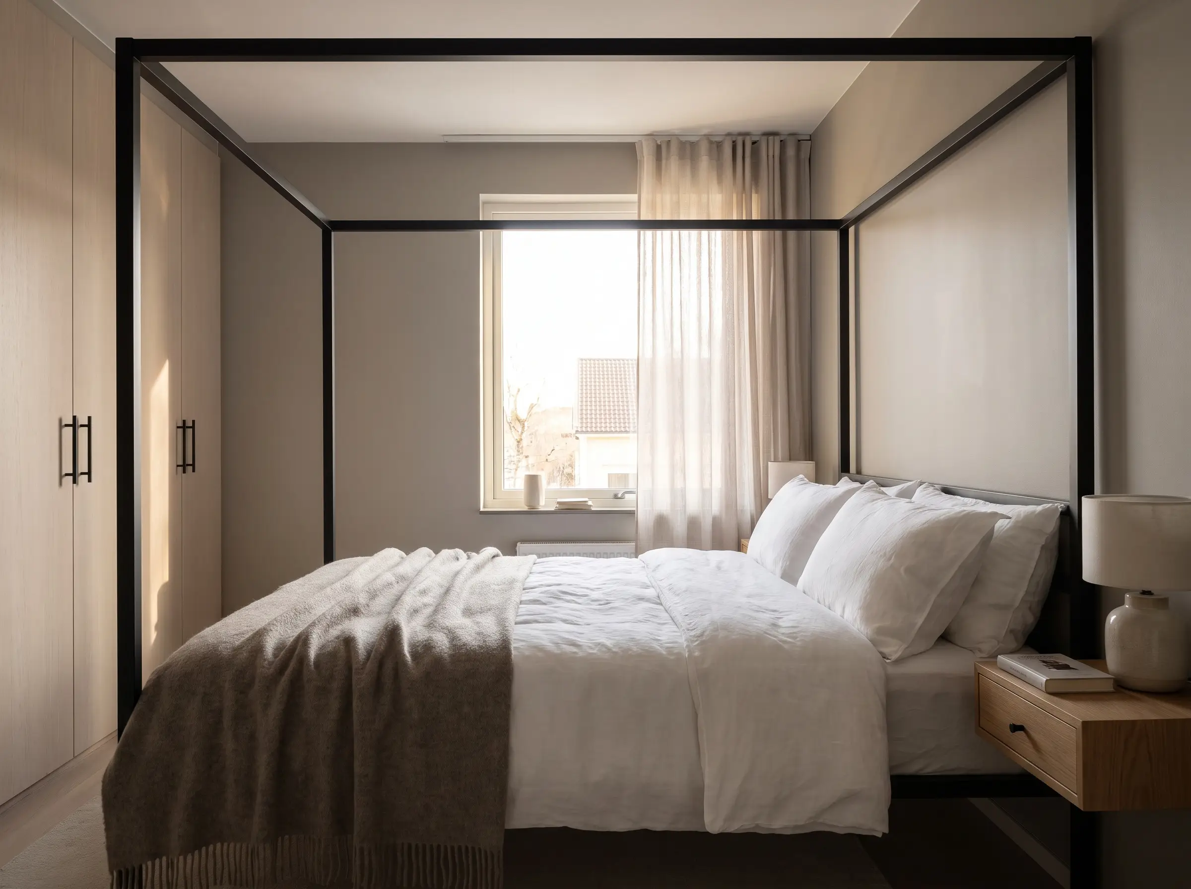 Crisp white bedding and a matte black metal bed frame contrast against light gray Behr paint on standard bedroom walls.
