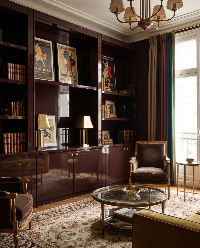 Custom bookcase millwork painted in Sherwin-Williams Rookwood Dark Red features a highly reflective high-gloss lacquer finish in an Art Deco living space.