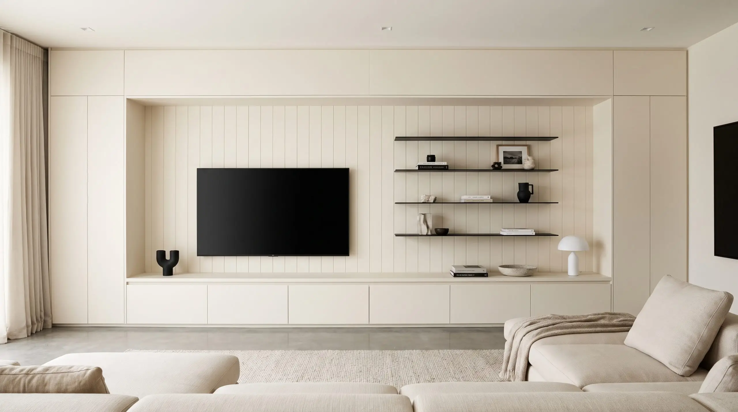Vertical tongue and groove pine planks painted seamless Alabaster back a recessed built-in media console holding a matte black television and minimal steel shelving.