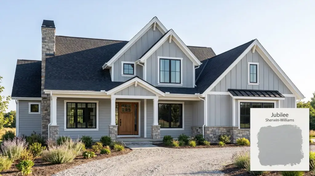 A modern farmhouse exterior features natural stone accents, crisp white trim, and siding painted in Sherwin-Williams Jubilee (Hex #ADB5B9) under clear midday skies.