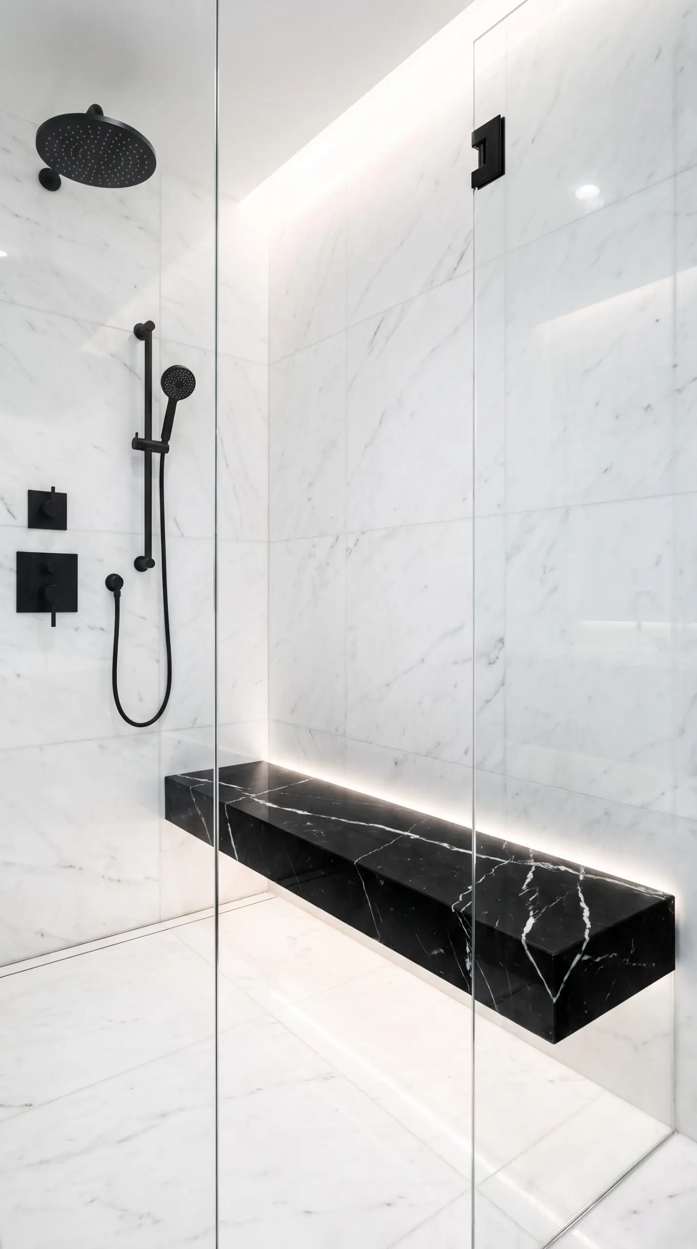 A stark black Nero Marquina polished marble floating bench with striking white veining contrasts against an all-white marble shower enclosure and matte black hardware.