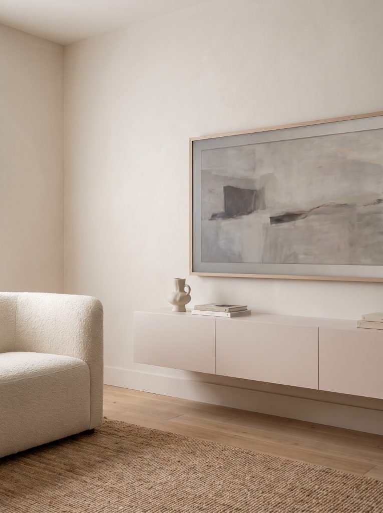 A handle-less floating media console painted Portola Paints El Mirage blends seamlessly beneath a framed art display screen in a modern minimalist living room.