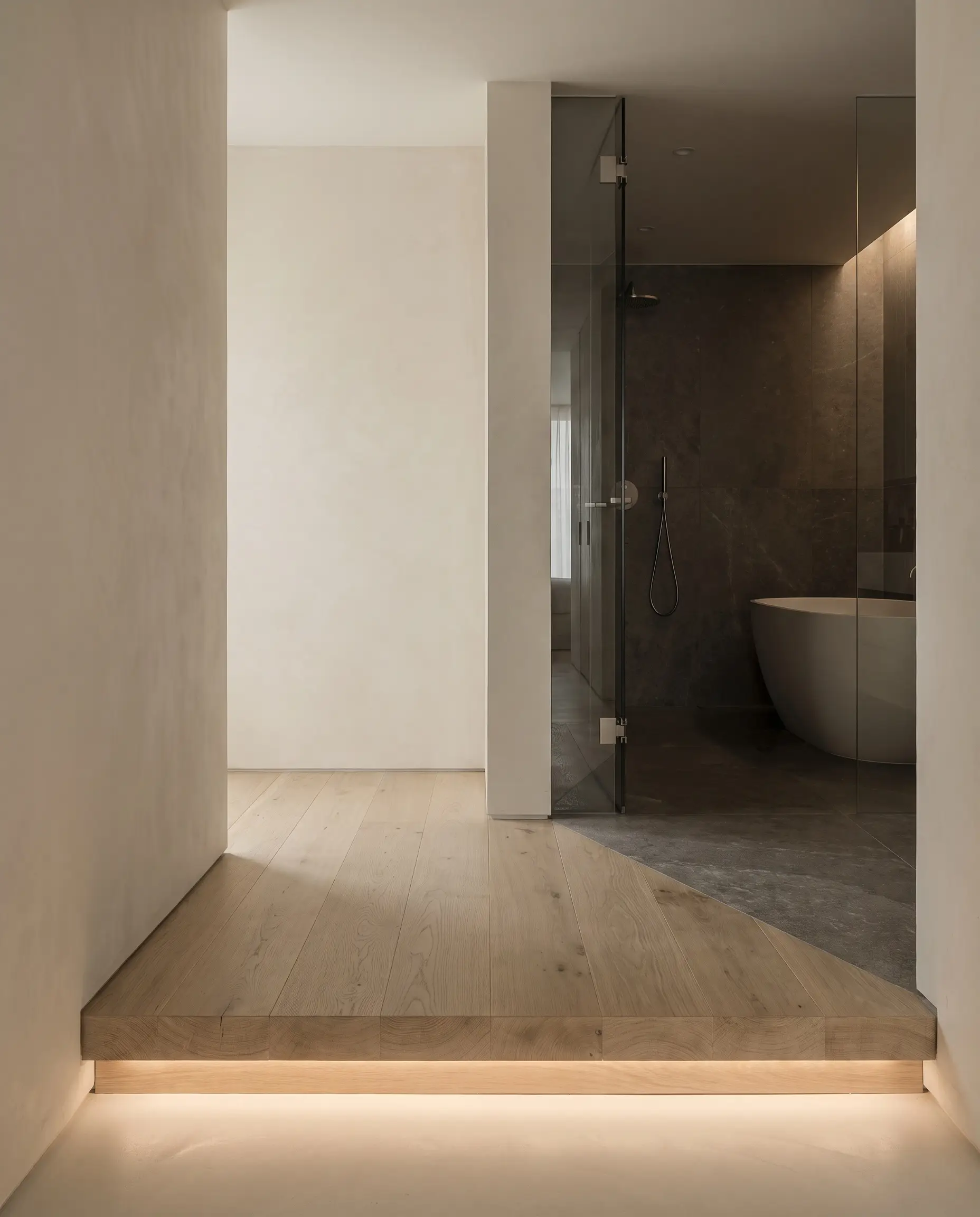 Solid rift-sawn white oak planks form a raised architectural transition step bridging a dry dressing space and a wet sanctuary against warm white walls.