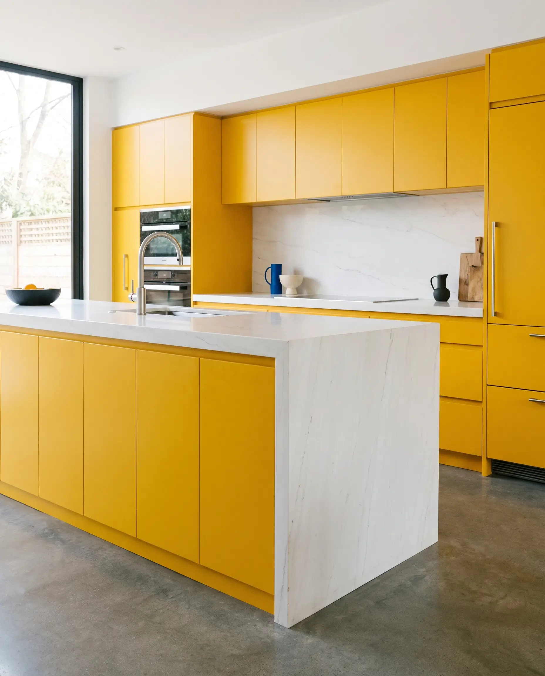 A thick waterfall-edge bright white quartzite with minimal veining wraps around a block of saturated yellow millwork in a high-end postmodern layout.