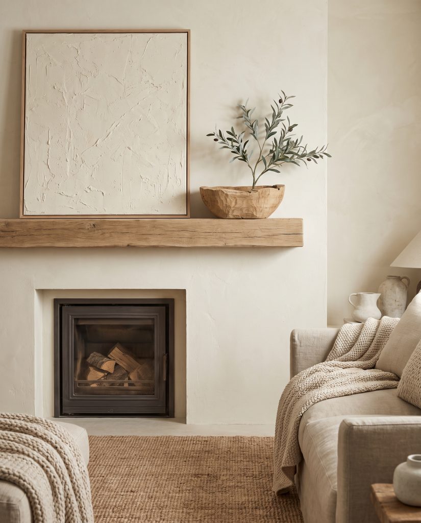 A heavily textured plaster canvas, a raw rift-sawn oak bowl, and a faux olive branch sit against a Benjamin Moore White Dove painted wall.