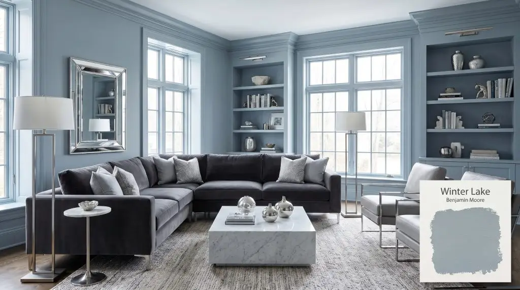 A charcoal velvet sofa and white marble coffee table center a sophisticated living room painted in Winter Lake 2129-50 (Hex #9CADB7).