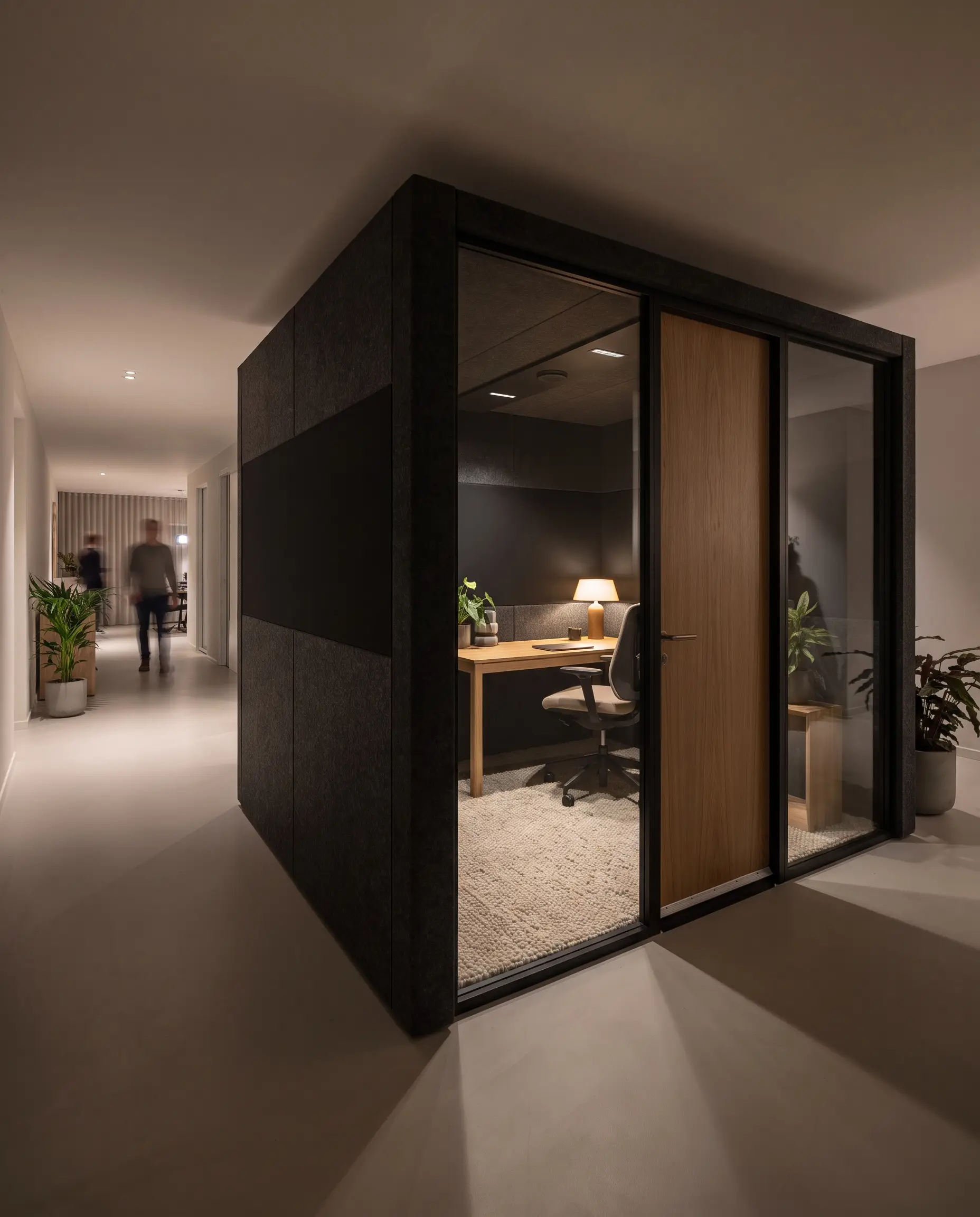 A heavy-pile wool rug and matte-black walls ground this enclosed micro-environment, reflecting office design trends 2027 for low-stimulus deep work.