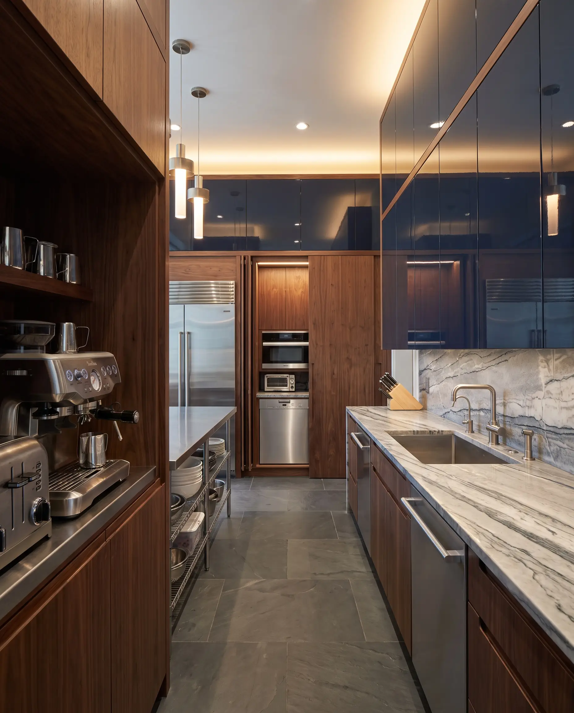 Bespoke pocket-door appliance garages clad in rich European walnut conceal heavy utility appliances above deeply veined soapstone counters and striking high-gloss lacquered upper cabinets.