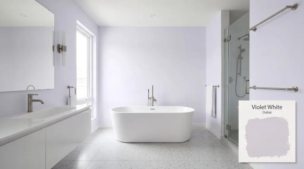 A freestanding white tub rests on light gray terrazzo flooring within a contemporary bathroom painted in Dulux Violet White (Hex #DEDCE6).