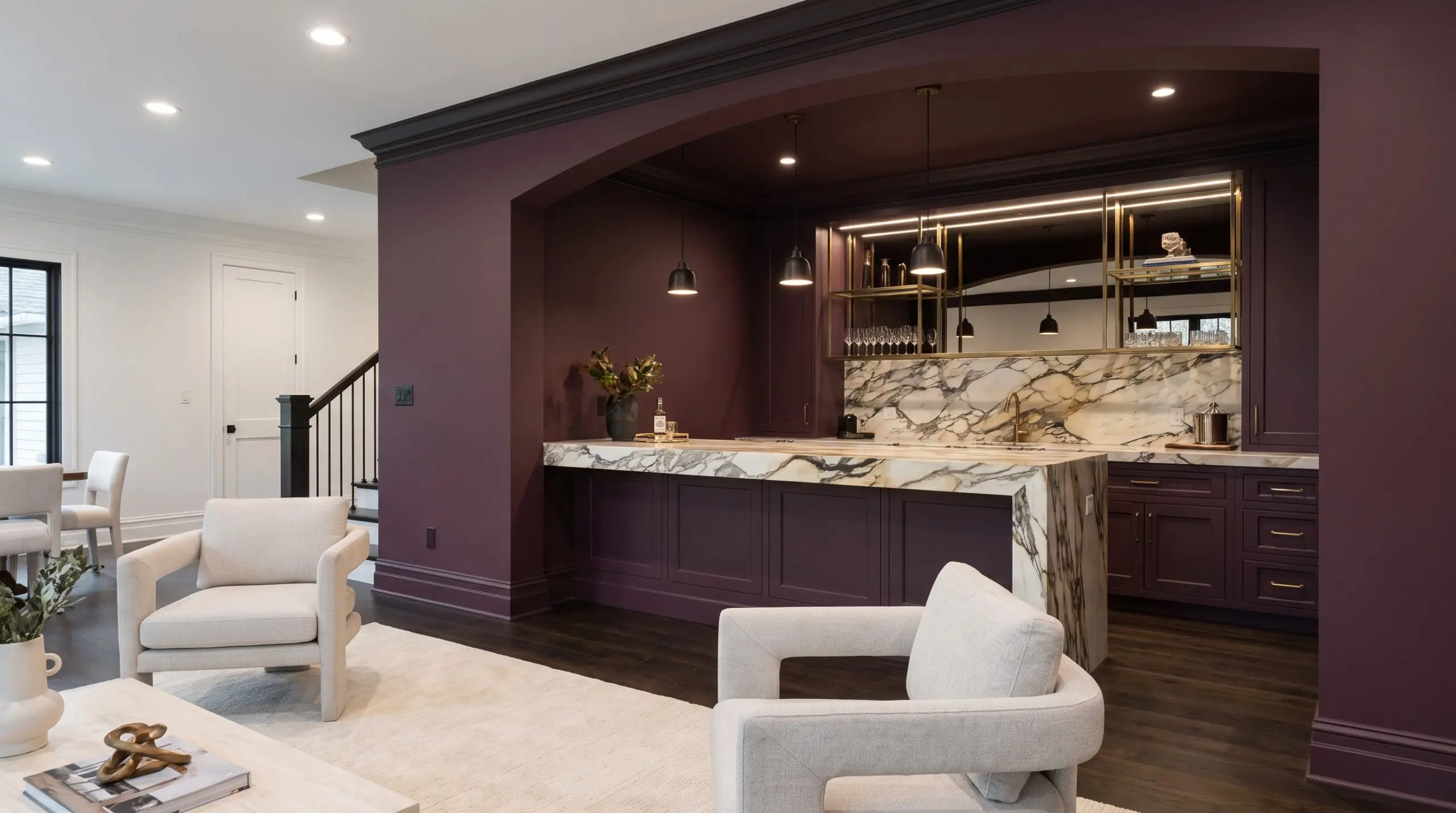 Walls and millwork drenched in Farrow and Ball Brinjal contrast with heavily veined marble countertops, showcasing bold home bar and wine storage trends.