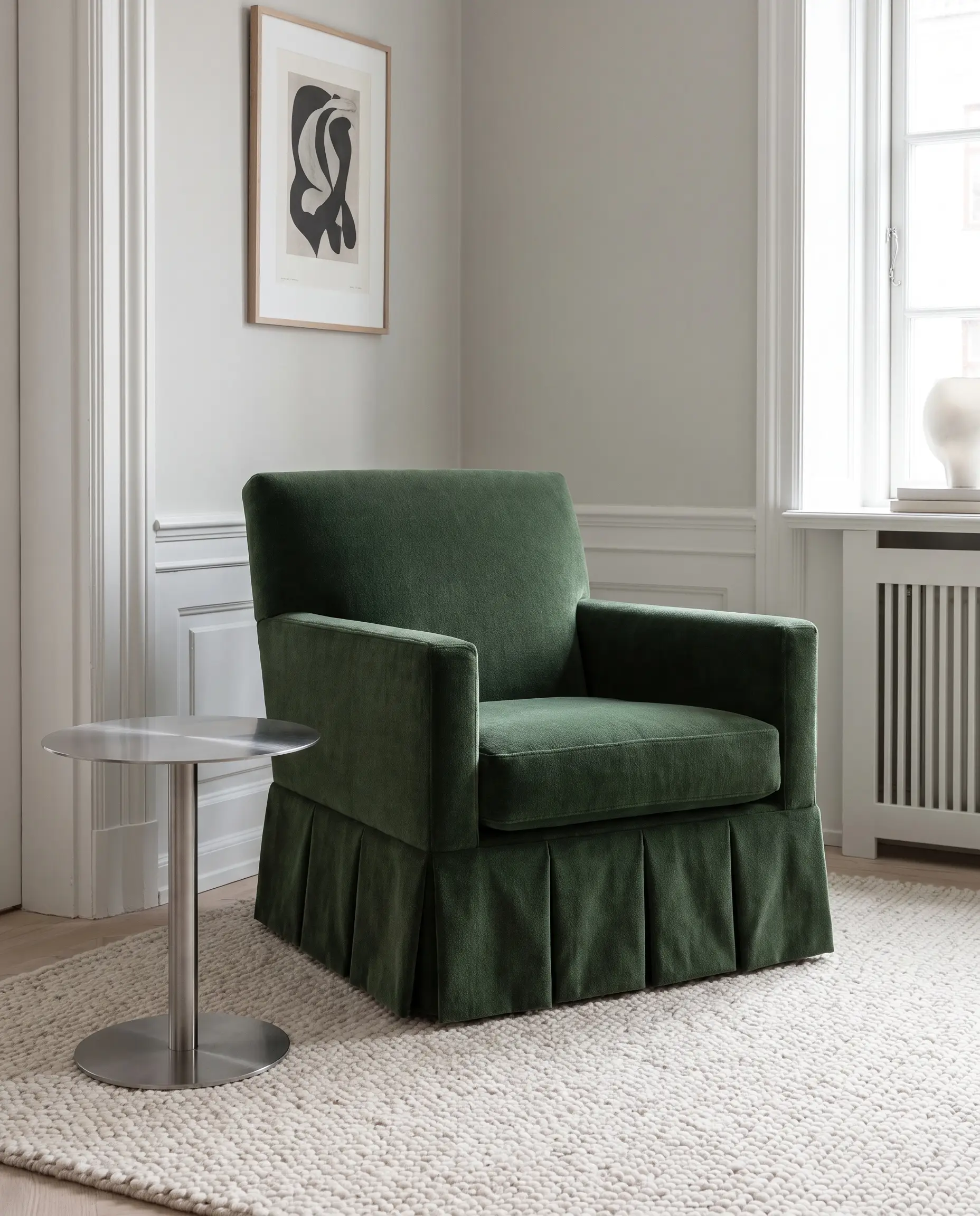 Poltrona sartoriale in mohair verde con mantovana a pieghe baciate accanto a un tavolino in acciaio spazzolato, icona delle tendenze arredo living 2027.