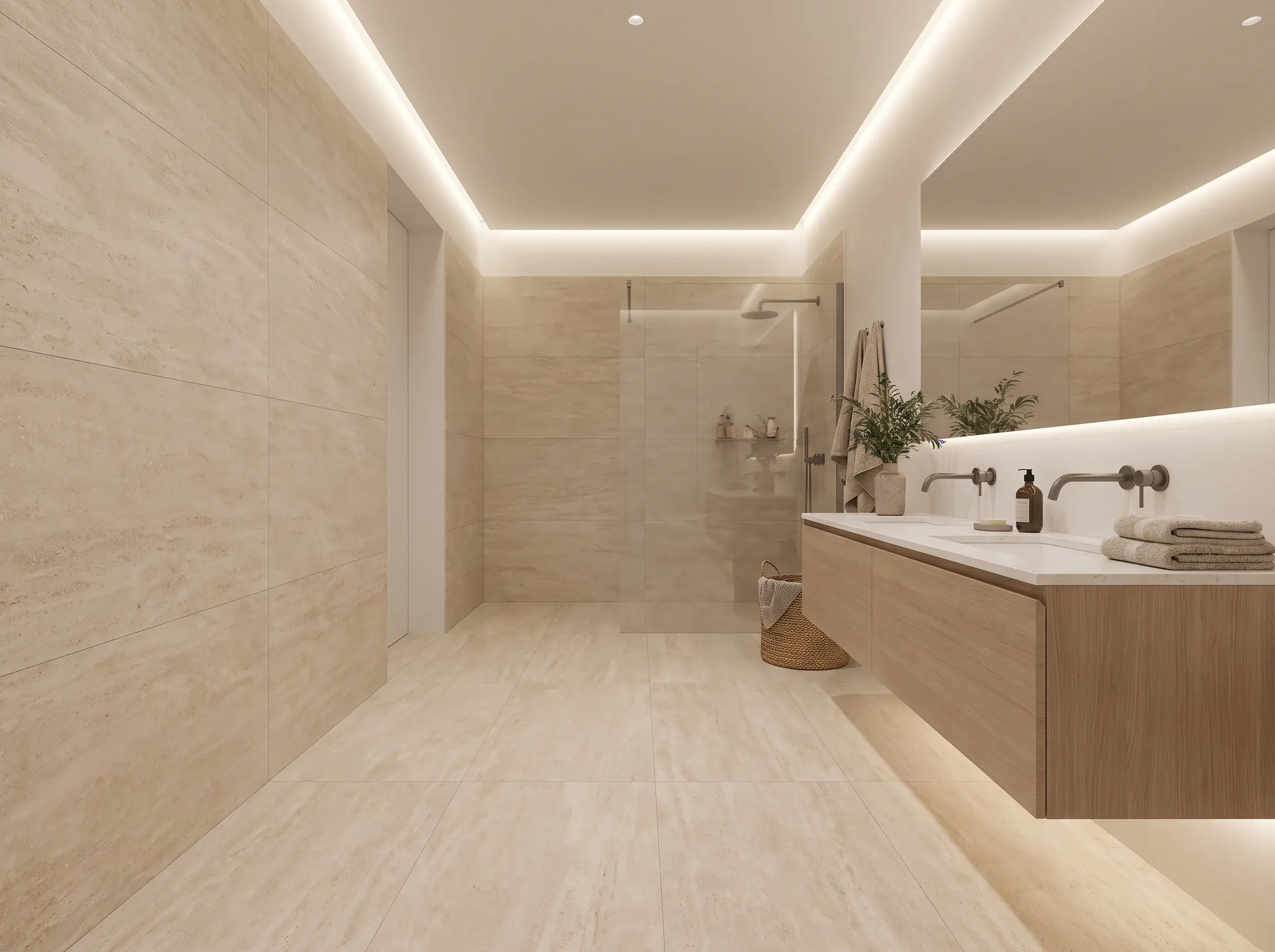 Grandi lastre in gres porcellanato con leggere venature effetto travertino creano una superficie continua sotto un mobile sospeso in rovere e un box doccia a filo.