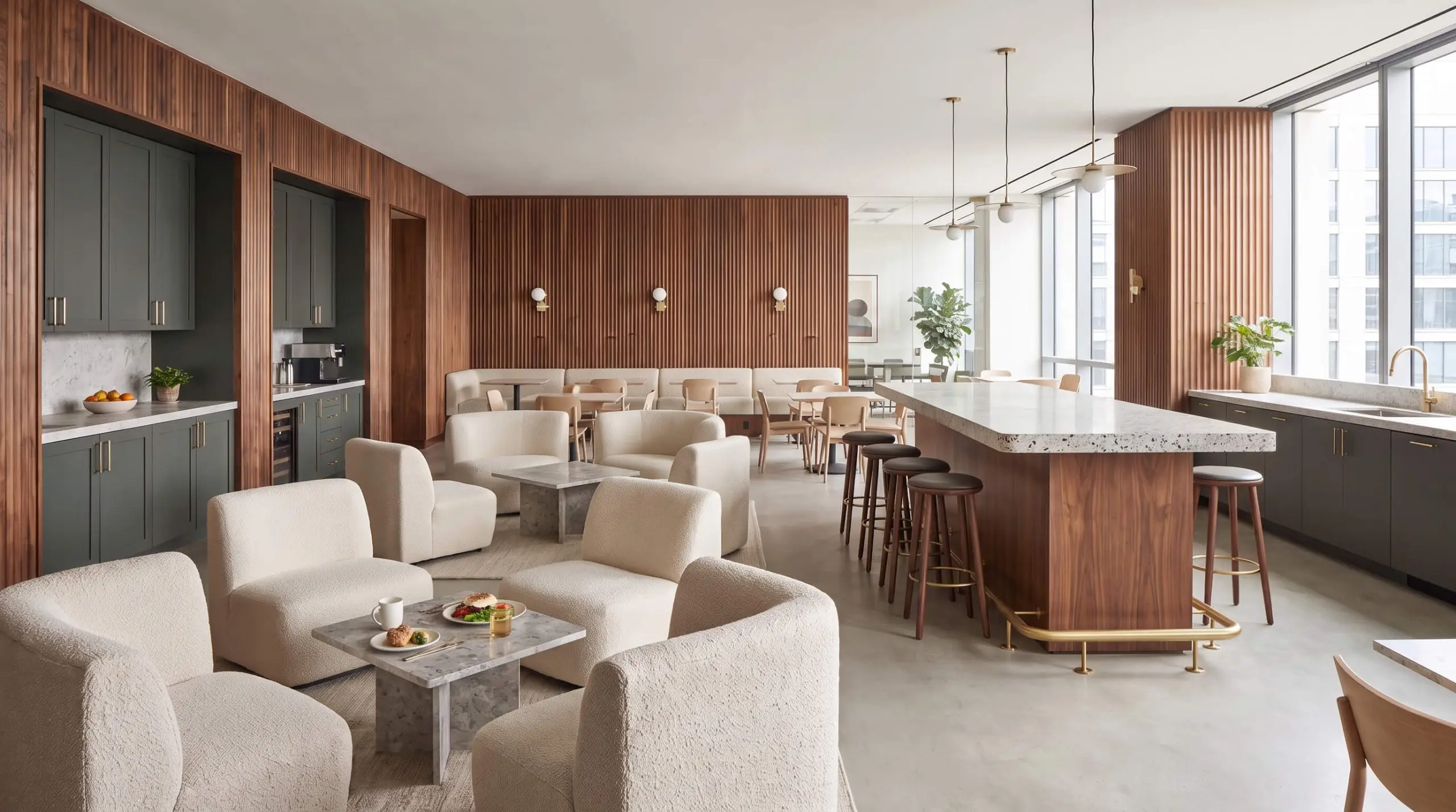 Farrow and Ball Studio Green perimeter casework and fluted walnut paneling surround a standing-height stone bar island and bouclé lounge seating.